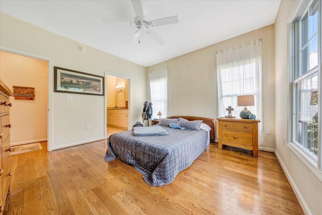 bedroom featuring ceiling fan, light wood-type flooring, and ensuite bath