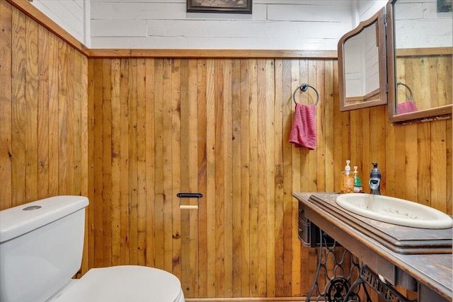 bathroom with wooden walls and toilet