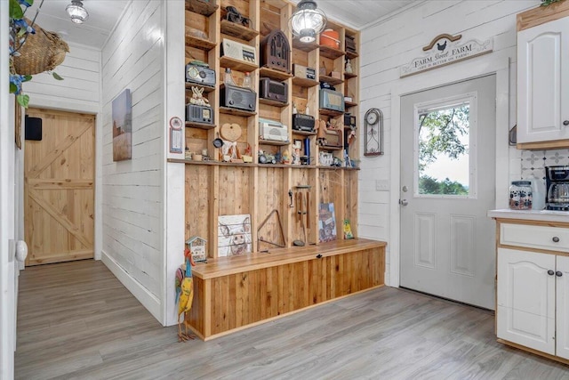 interior space featuring a barn door, wooden walls, and light wood-type flooring