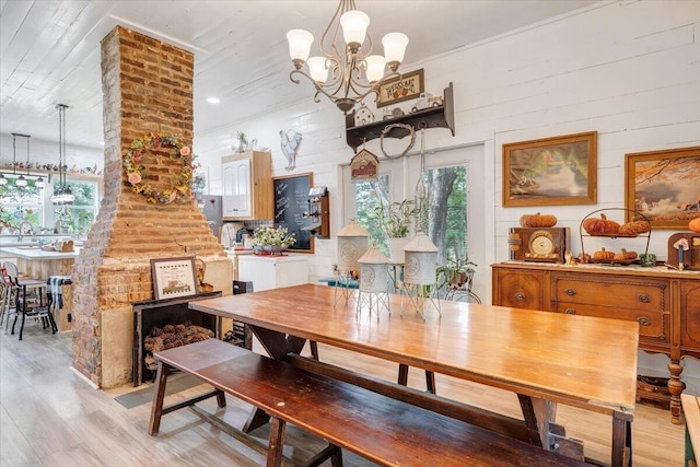 dining area with a notable chandelier, sink, a healthy amount of sunlight, and light wood-type flooring