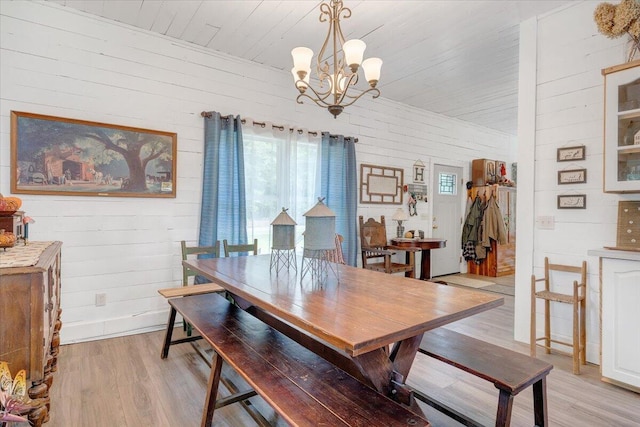 dining area featuring an inviting chandelier, wooden walls, light hardwood / wood-style floors, and wooden ceiling