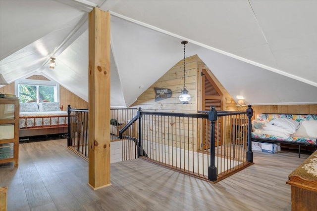 additional living space featuring vaulted ceiling, hardwood / wood-style floors, and wooden walls