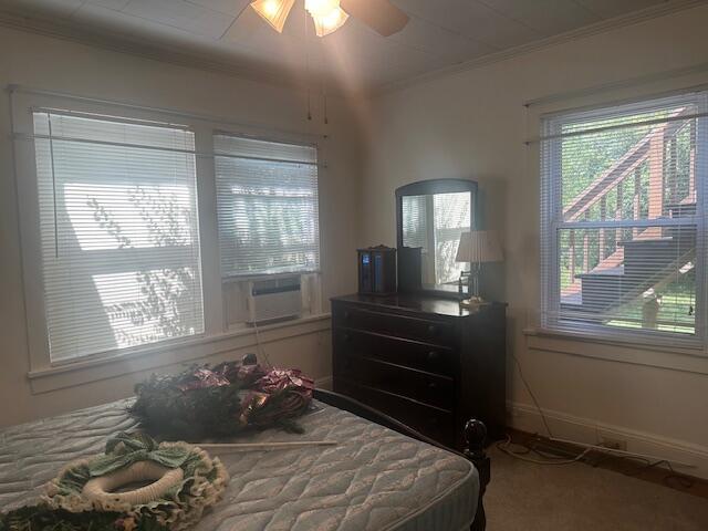 bedroom with crown molding, carpet, ceiling fan, and cooling unit