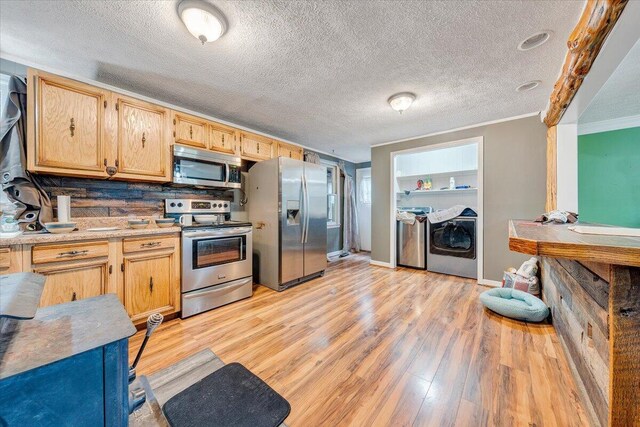 kitchen with light wood-type flooring, a textured ceiling, decorative backsplash, appliances with stainless steel finishes, and ornamental molding