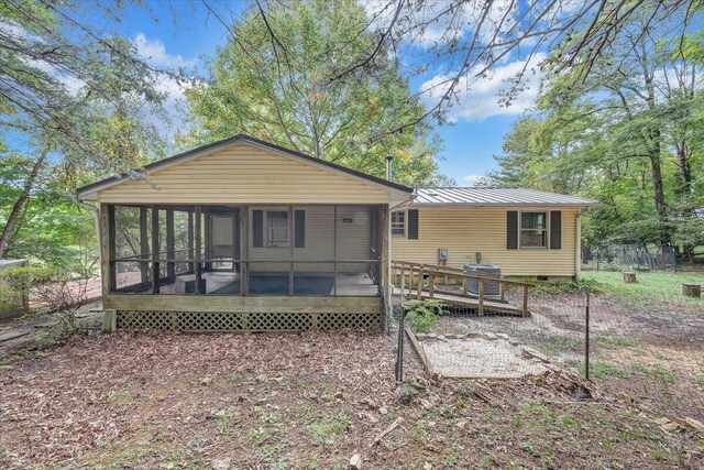 back of property with a wooden deck and a sunroom