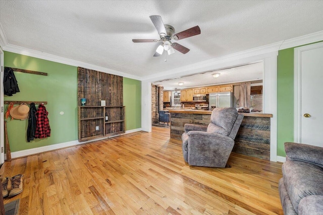 living room featuring ceiling fan, a textured ceiling, crown molding, and light hardwood / wood-style floors