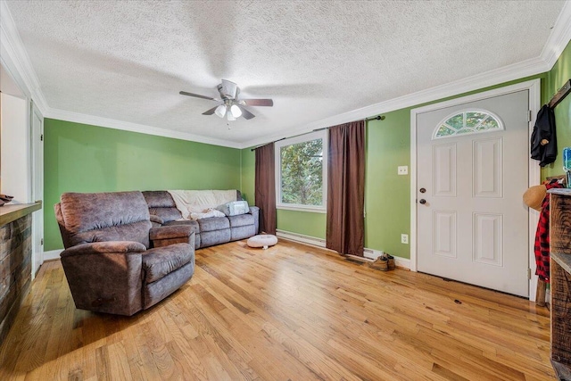 living room featuring ceiling fan, a textured ceiling, light hardwood / wood-style floors, and a healthy amount of sunlight