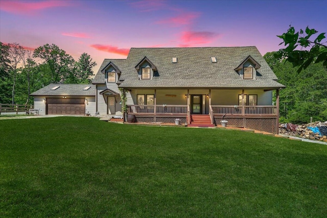 view of front of home featuring a lawn, a porch, and a garage