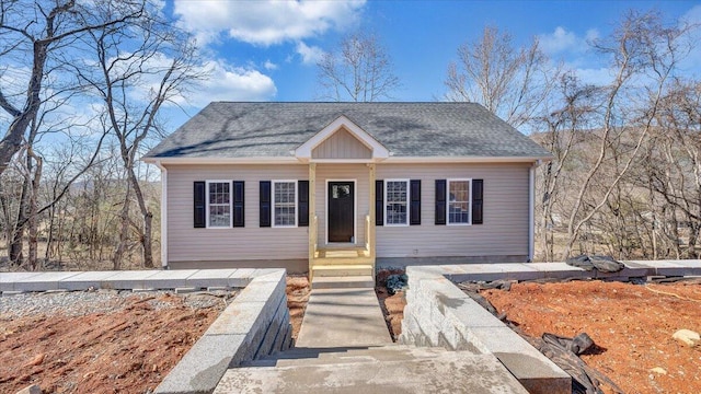 bungalow featuring roof with shingles