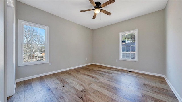 empty room featuring baseboards, ceiling fan, and light wood finished floors