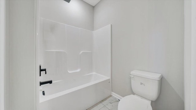 bathroom with toilet, marble finish floor, baseboards, and tub / shower combination