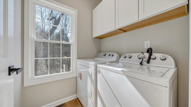 laundry area featuring cabinet space, visible vents, baseboards, and washer and dryer