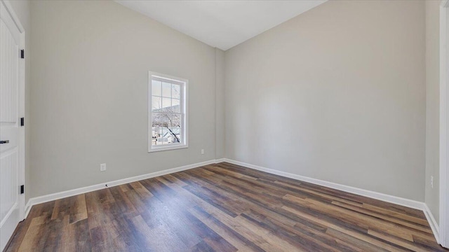 empty room featuring baseboards and dark wood-style flooring