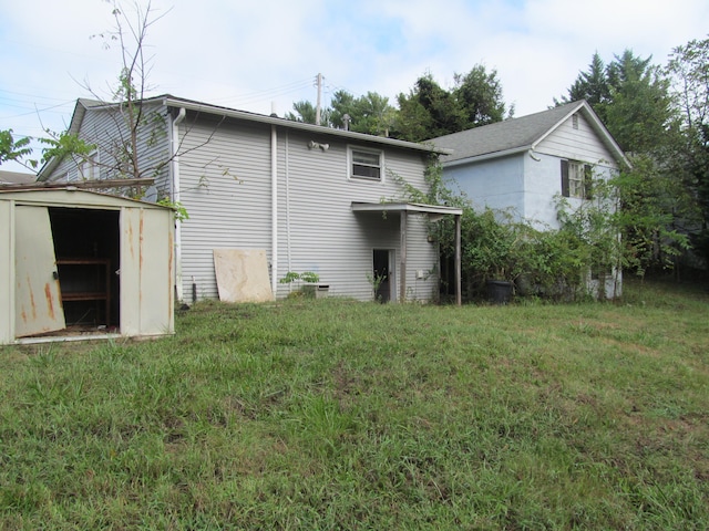 rear view of house with a shed and a yard