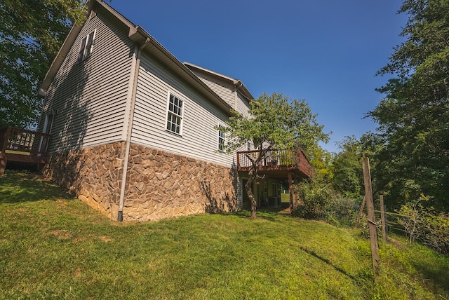 view of property exterior featuring a yard and a wooden deck