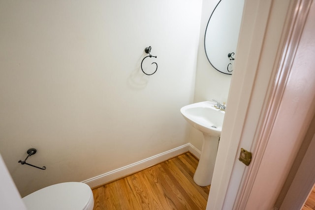 bathroom featuring toilet, sink, and hardwood / wood-style floors