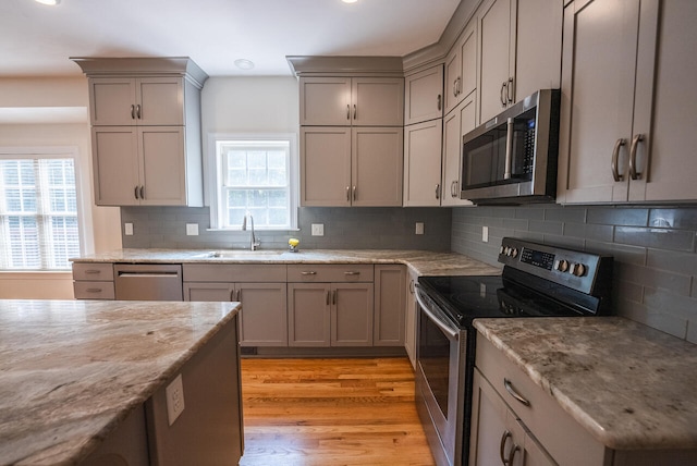 kitchen featuring gray cabinetry, stainless steel appliances, a healthy amount of sunlight, and sink