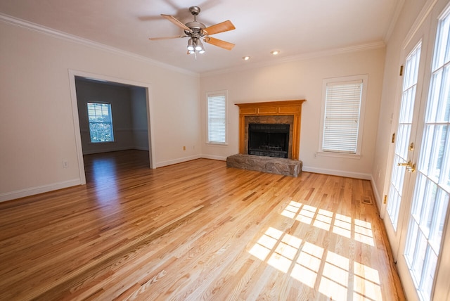 unfurnished living room with ceiling fan, plenty of natural light, and a stone fireplace