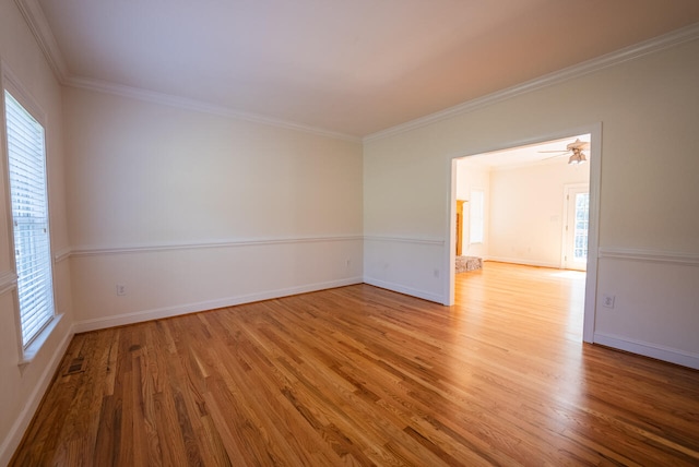 empty room featuring light wood-type flooring and ornamental molding