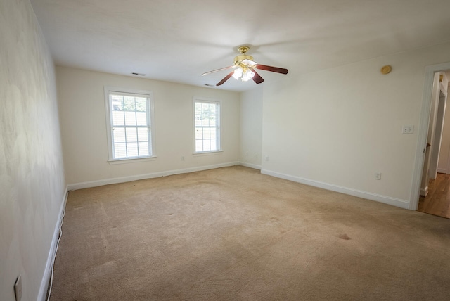 spare room featuring ceiling fan and light carpet