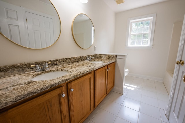 bathroom featuring a tub to relax in, vanity, toilet, and tile patterned floors