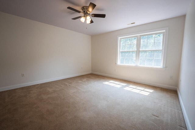 unfurnished room with ceiling fan and carpet flooring