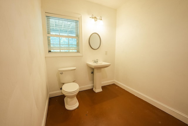 bathroom with concrete floors and toilet