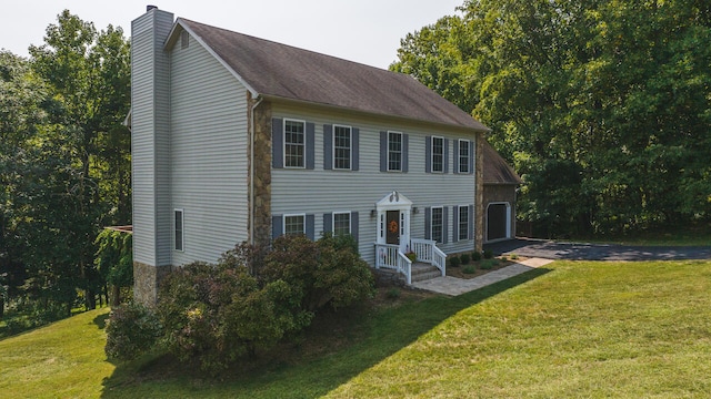 colonial home featuring a front lawn and a garage