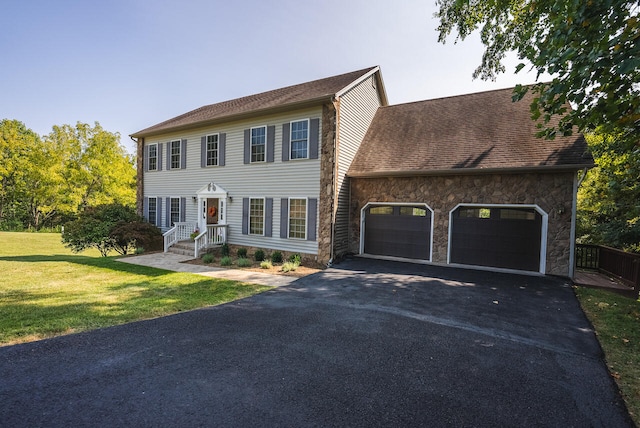 colonial home with a garage and a front lawn