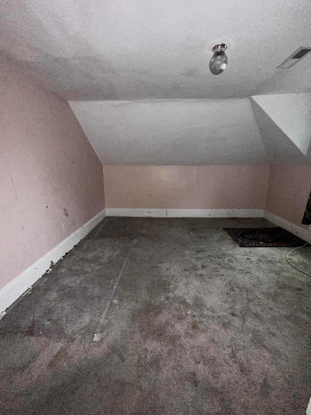 bonus room featuring a textured ceiling and lofted ceiling