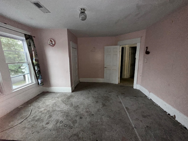 unfurnished room featuring a textured ceiling