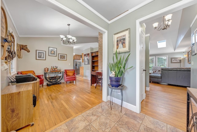 foyer with vaulted ceiling, an inviting chandelier, crown molding, and light hardwood / wood-style floors