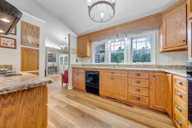 kitchen with light hardwood / wood-style floors, black dishwasher, lofted ceiling, range hood, and a chandelier