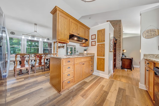 kitchen featuring light stone countertops, lofted ceiling, light hardwood / wood-style floors, and a healthy amount of sunlight