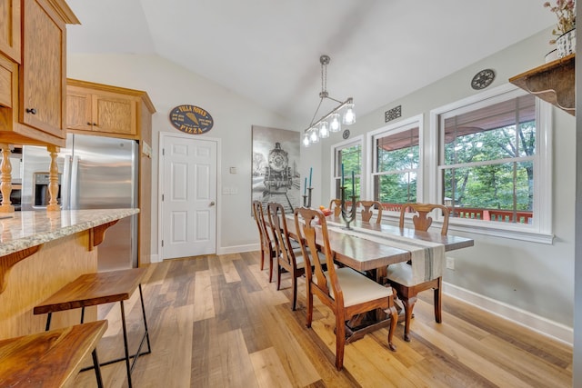 dining space with light wood-type flooring, lofted ceiling, and a chandelier