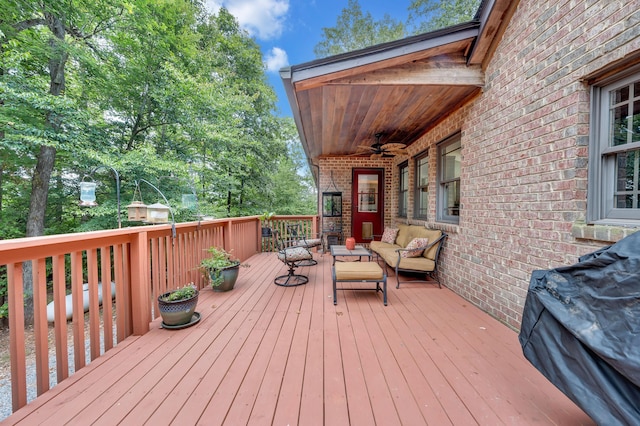 wooden terrace featuring ceiling fan and an outdoor living space