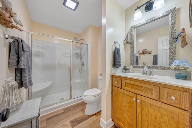 bathroom with walk in shower, vanity, toilet, and wood-type flooring