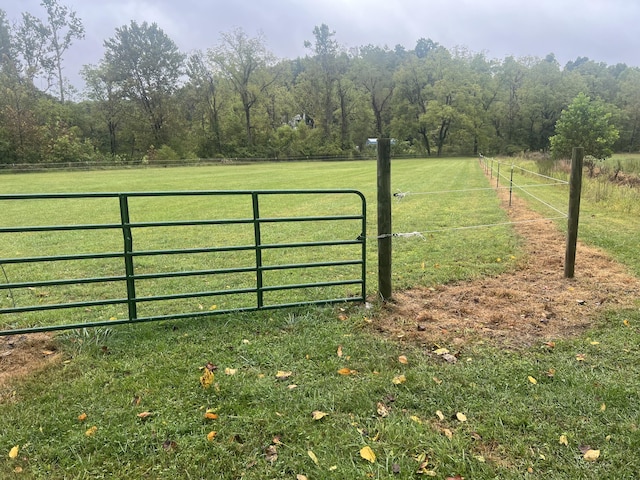 view of gate with a rural view and a yard