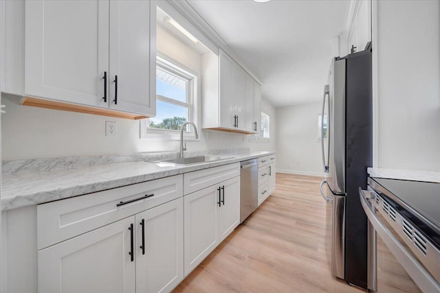 kitchen featuring a barn door, white cabinetry, sink, and stainless steel appliances