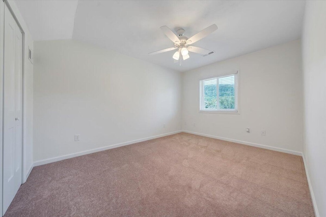 carpeted empty room with ceiling fan and vaulted ceiling