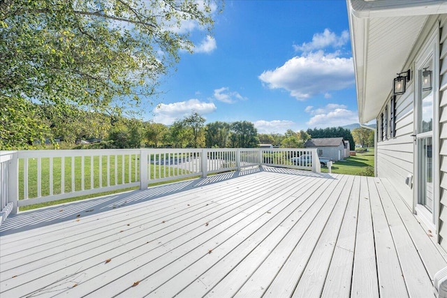 wooden deck featuring a lawn