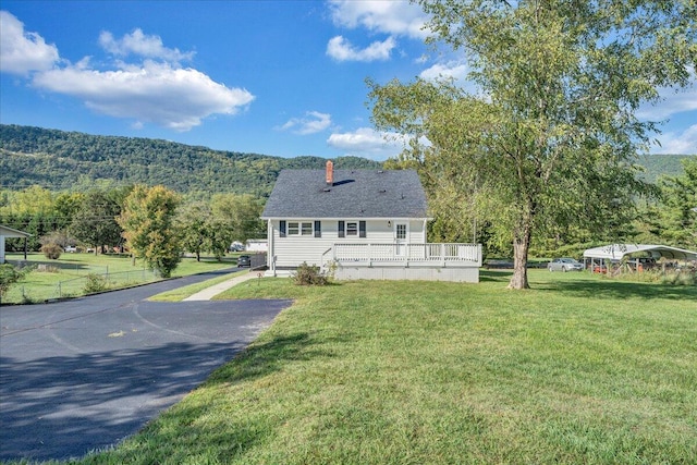 view of front of property featuring a mountain view and a front lawn