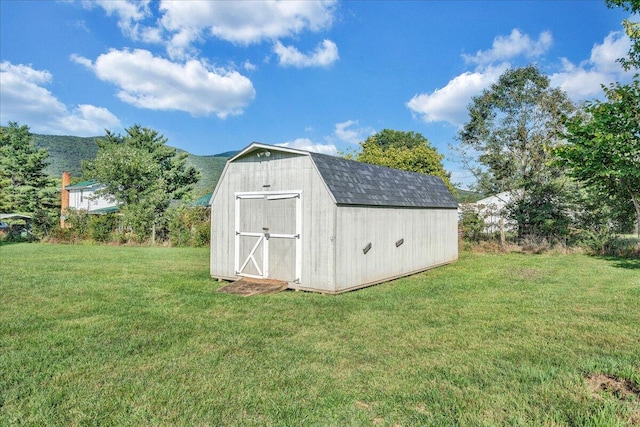 view of outbuilding with a mountain view and a lawn