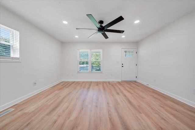 unfurnished room featuring ceiling fan, light wood-type flooring, and a healthy amount of sunlight