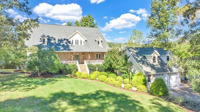 view of front of home with a garage, a porch, and a front yard