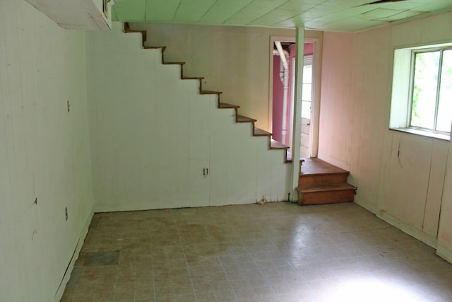 basement featuring wood walls