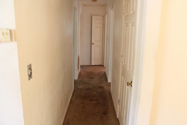 hallway featuring dark carpet