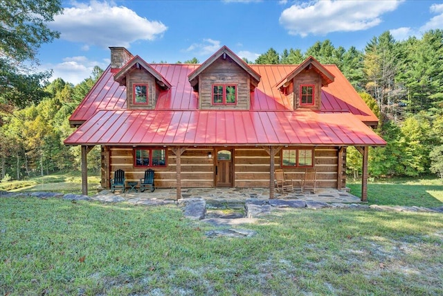 log cabin with a patio and a front lawn