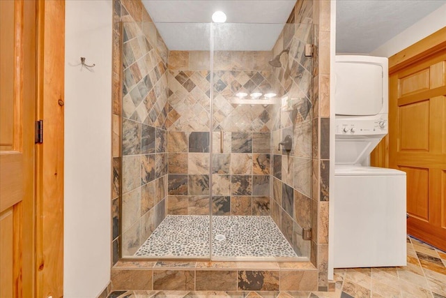 bathroom with an enclosed shower and stacked washing maching and dryer