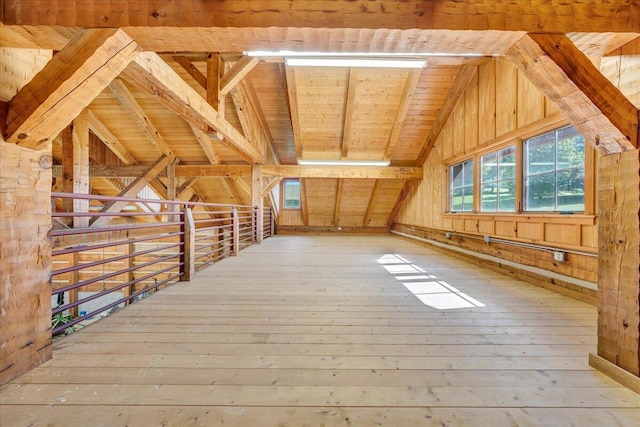 bonus room with wooden walls, wood ceiling, lofted ceiling with beams, and light hardwood / wood-style flooring